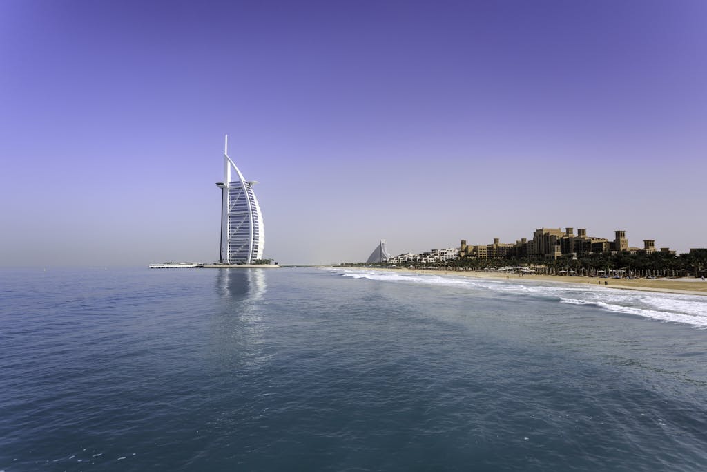 Iconic Burj Al Arab overlooking the pristine Dubai beach, perfect for travel and leisure.