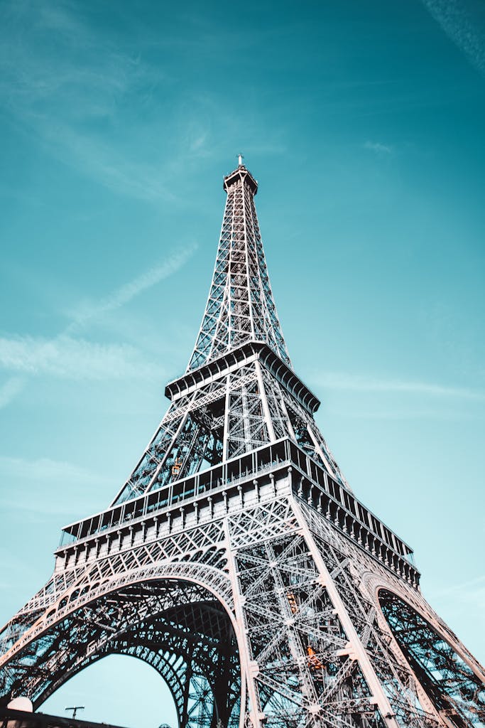 Stunning low angle view of the Eiffel Tower against a bright blue sky in Paris.